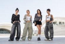 Diverse women wearing Acubi fashion outfits with baggy jeans, cargo pants, mini skirt, layered tops, chunky shoes, and silver accessories
