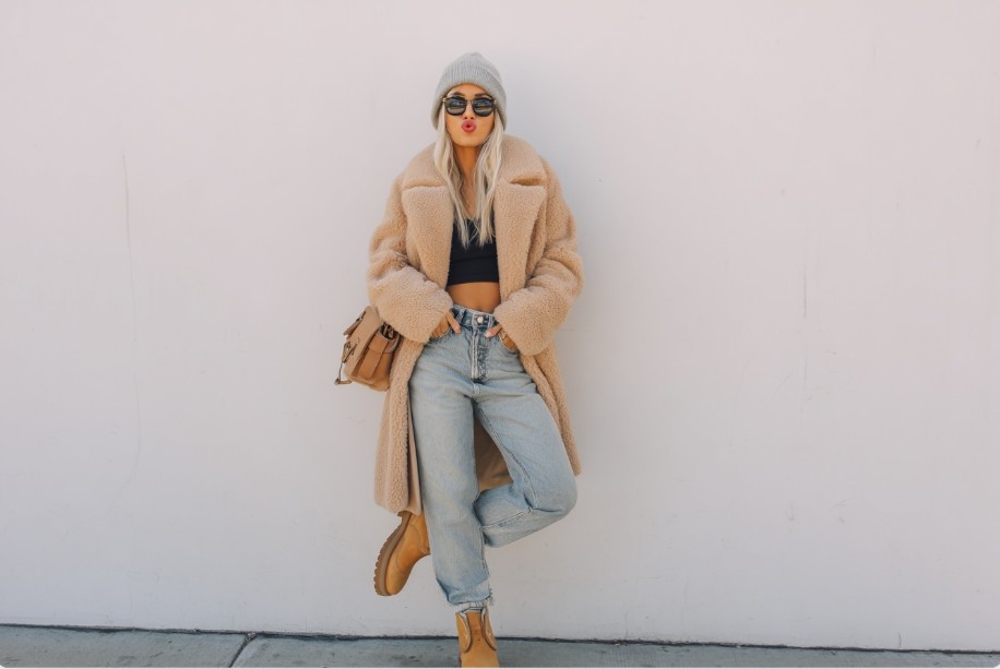 Fashionable winter outfit featuring a crop top styled with a long teddy coat and jeans
