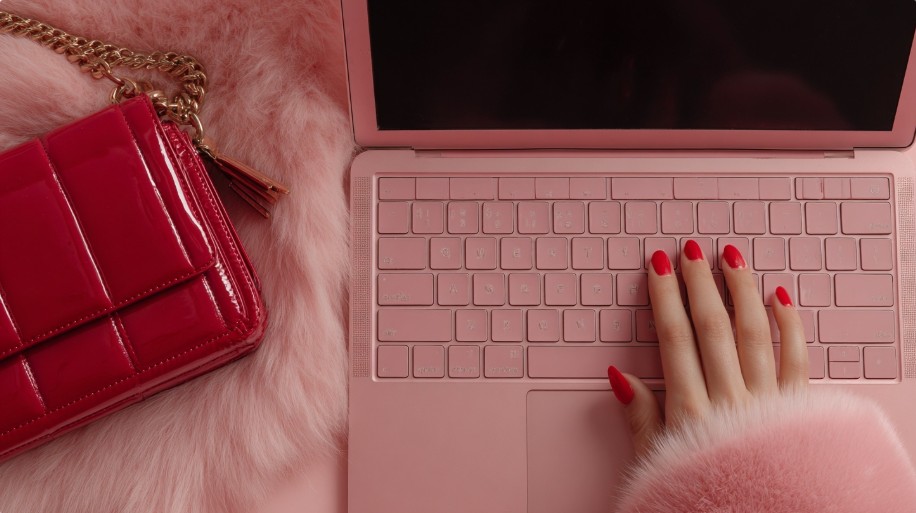 Aesthetic flat-lay of a pink laptop and purse symbolizing online comparison