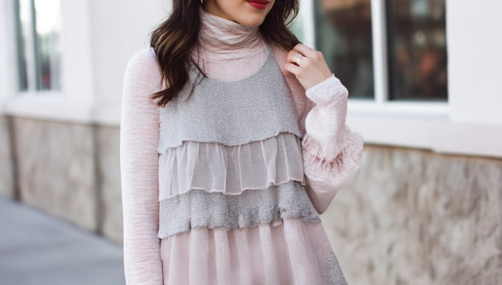 Layered babydoll top worn over a soft turtleneck creating a cozy modern outfit