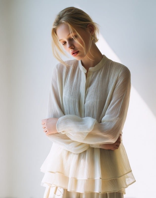 Tall model wearing longer babydoll top with coat fashion editorial look