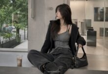 Acubi fall outfit with grey fitted tank, black zip hoodie, dark cargo pants, black shoulder bag, chunky black shoes, and muted city styling