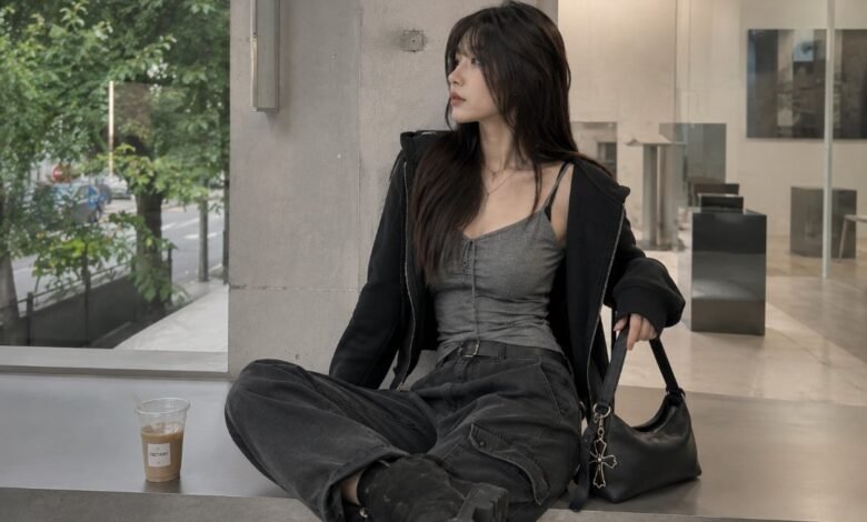 Acubi fall outfit with grey fitted tank, black zip hoodie, dark cargo pants, black shoulder bag, chunky black shoes, and muted city styling