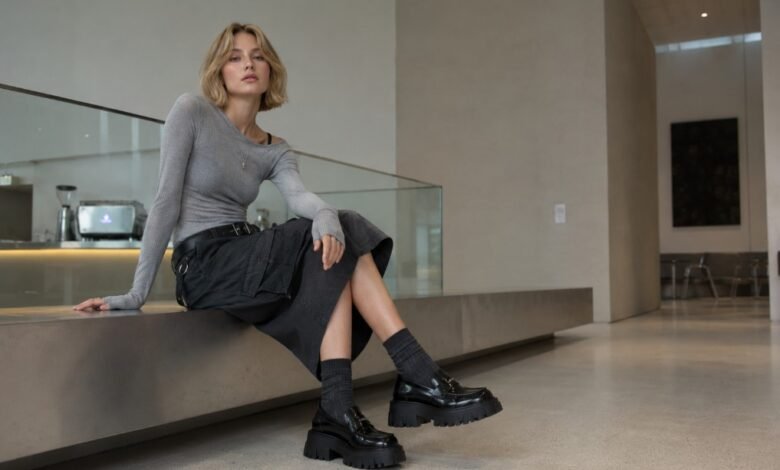 Acubi shoes outfit with black chunky loafers, dark socks, cargo skirt, fitted grey top, and modern city museum styling