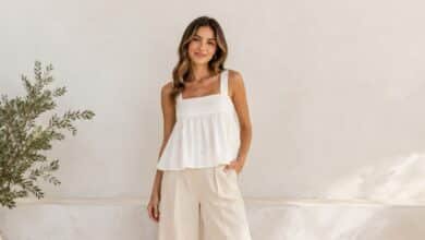Woman wearing a white babydoll top with cream wide-leg pants in a clean neutral outfit