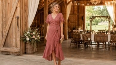 Woman wearing a rose wrap dress as a barn wedding guest inside a rustic wedding reception venue