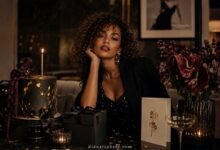 Luxury fashion magazine style birthday cover with curly-haired woman, black cake, candles, gift box, flowers, and birthday card