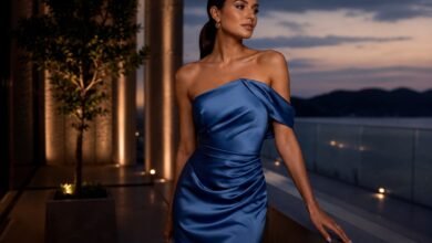 Elegant woman in a blue satin wedding guest dress on a luxury evening balcony