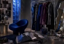 How a Brand Becomes a Personality, Not Just a Logo 6 Moody fashion studio with clothing rack, blue velvet chair, fashion magazine, perfume, silver jewelry, camera, mirror, and dark aesthetic brand mood