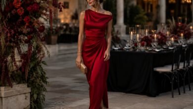 Woman in an elegant red satin wedding guest dress at an evening garden wedding reception
