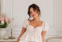 Woman wearing a romantic white lace babydoll top in a soft editorial fashion portrait