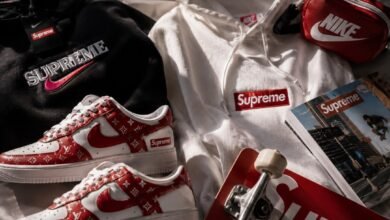 Nike x Supreme streetwear flat lay with red and white sneakers, hoodies, skateboard, pouch, magazine, and hype collab fashion details
