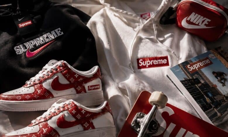 Nike x Supreme streetwear flat lay with red and white sneakers, hoodies, skateboard, pouch, magazine, and hype collab fashion details