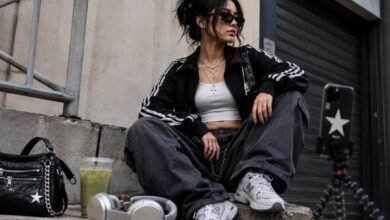 TikTok Trends That Survive Outside the Algorithm 8 Acubi-inspired TikTok fashion street style with sporty jacket, baggy cargo jeans, chunky sneakers, silver accessories, phone tripod, and headphones