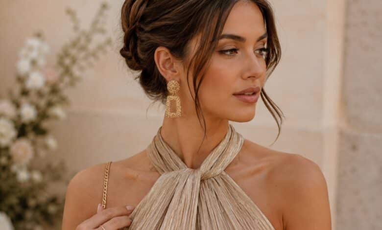 Close-up portrait of a wedding guest wearing gold statement earrings and an elegant halter dress