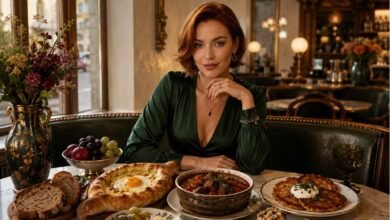Stylish European bistro table with khachapuri, goulash, potato pancakes, pickles, bread, dessert, fruit and cozy dinner atmosphere
