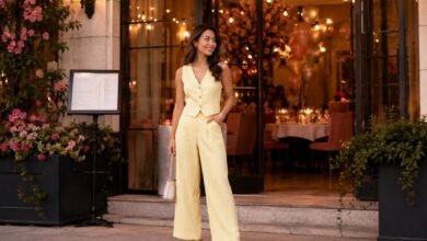 Stylish guest arriving at a friend’s birthday dinner in a pale yellow tailored jumpsuit with heels and a small handbag.