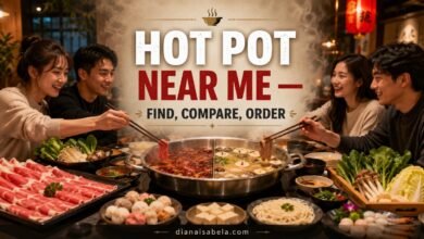Friends sharing divided hot pot with sliced meat, vegetables, noodles and dipping sauces