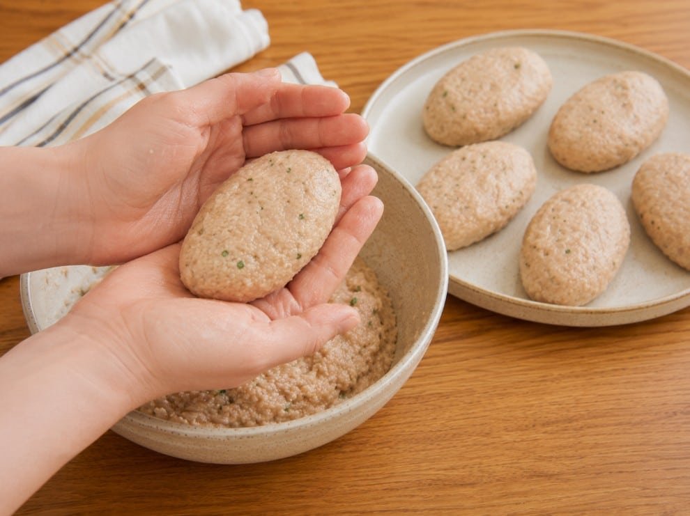 Hands shaping ground turkey mixture into oval kotleti