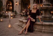 Burgundy velvet fall wedding guest dress styled for an elegant evening courtyard wedding.