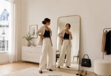 Woman checking outfit proportions in a mirror to understand why the look feels unbalanced