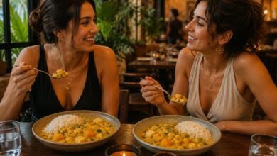 wo stylish women eating traditional Peruvian locro de zapallo with white rice at a Peruvian restaurant
