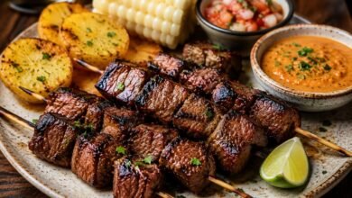 Bolivian beef heart anticuchos with grilled potatoes, peanut llajua, chile sauce and lime
