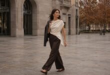 Stylish woman walking through a modern city plaza in a fluid outfit that shows natural fabric movement